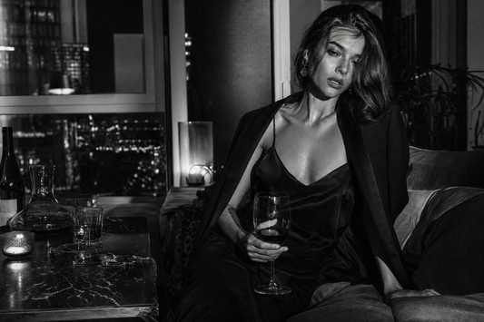 Stylish woman with wine in a moody upscale apartment after a long night out